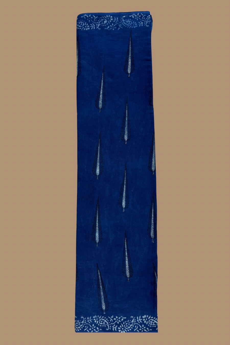 Blue fabric with white embroidery on a brown background